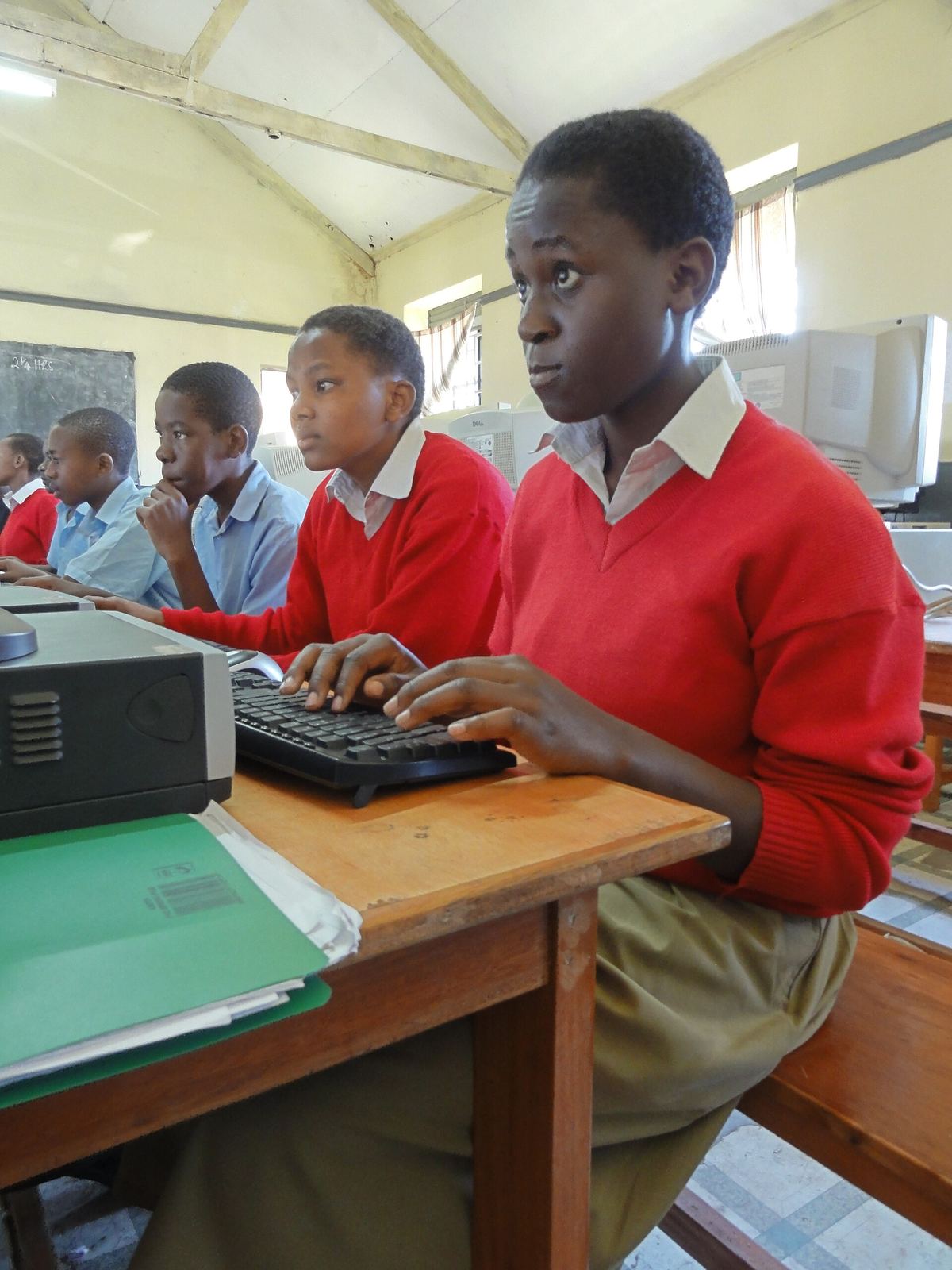 students practising on computers in a school lab