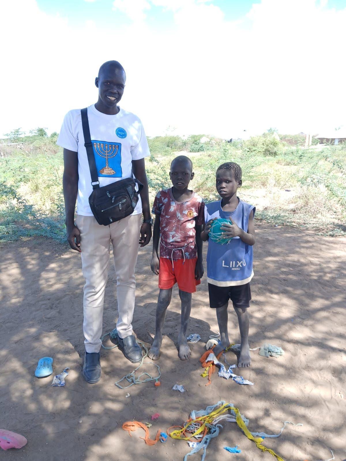 Young footballers holding a ball with their coach